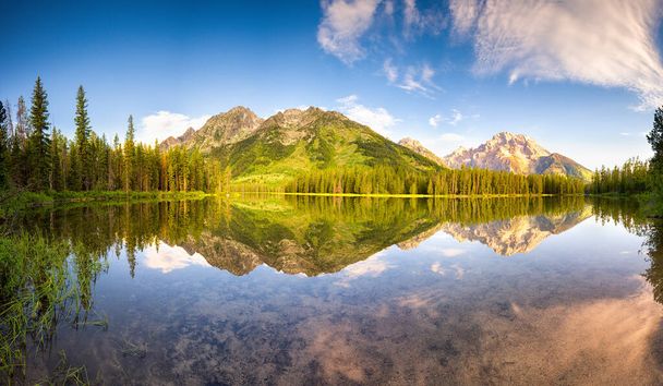 Agua perfectamente tranquila con reflejos brillantes en el lago String en el Parque Nacional Grand Teton, WY
 - Foto, imagen