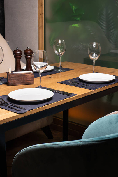 Uma mesa de madeira quadrada e sofás. Uma mesa de serviço no restaurante. É um belo serviço.
 - Foto, Imagem