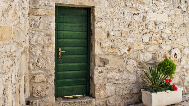 Casco antiguo en Croacia, edificio de piedra, puerta verde. Tema fondo de pantalla, idílico, acogedor, colorido, día soleado, vacaciones
 - Foto, Imagen