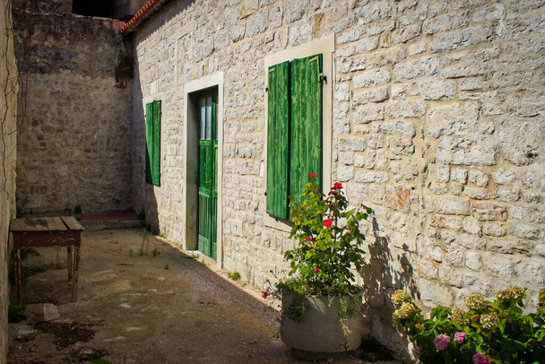 Óváros Horvátországban, kőépület, zöld ajtó. Téma tapéta, idilli, hangulatos, színes, napos nap, nyaralás - Fotó, kép