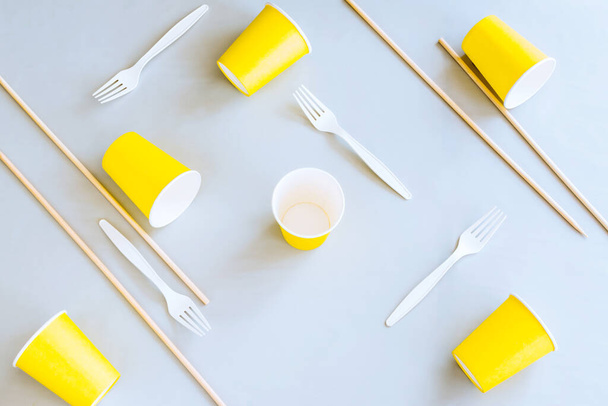 Eco-friendly disposable tableware on a gray background. Paper cups, biodegradable Cutlery, wooden skewers. The concept of zero waste. The view from the top. Copy space - Photo, Image