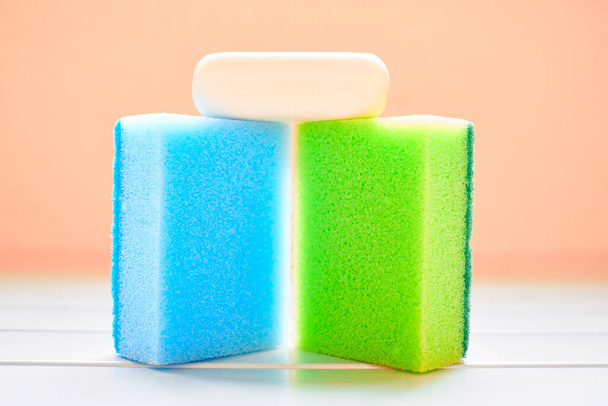 Two colored sponges and white soap for cleaning - Fotó, kép