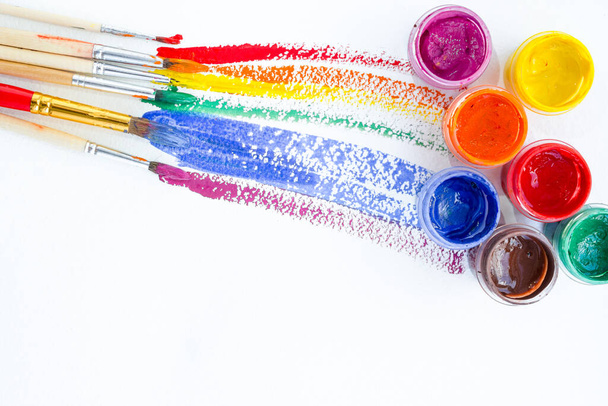 boîtes de gouache de peinture colorée avec des rayures et des pinceaux colorés - Photo, image