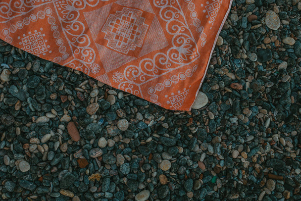 Pomarańczowy materiał z wzorem na szarych kamyczkach - Zdjęcie, obraz