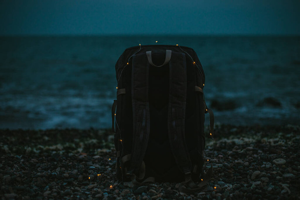 Σακίδιο πλάτης με φώτα στην παραλία το βράδυ - Φωτογραφία, εικόνα