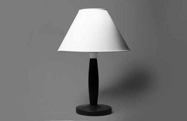 Minimaal close-up portret van kamerlamp in zwart-wit op grijze achtergrond. - Foto, afbeelding