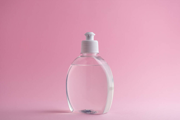 Hand sanitizer bottle or antiseptic gel on a delicate pink background - Fotoğraf, Görsel