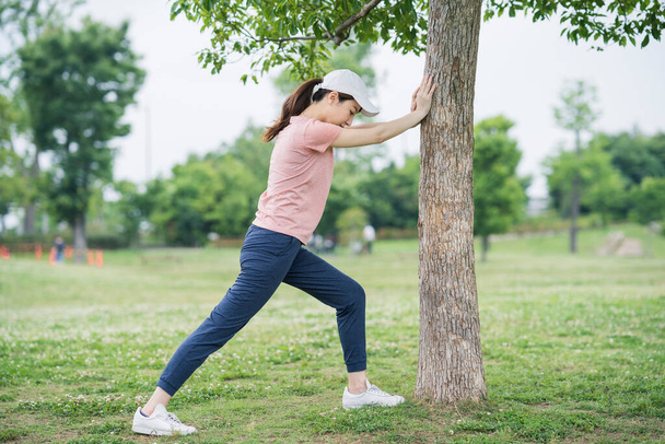 Азійська молода жінка в спортивній манері та на тренуваннях у парку. - Фото, зображення