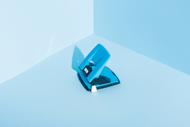 perforateur en plastique bleu sur fond bleu - Photo, image