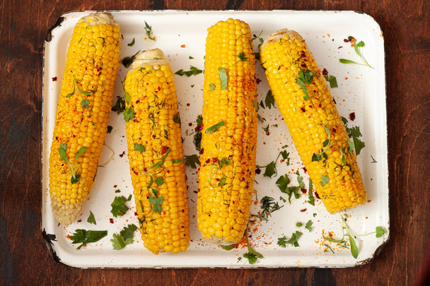 Boiled corn with butter, cilantro and paprika. Summer food - Foto, imagen