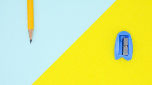 yellow pencil and blue  pencil sharpener on blue and yellow  background - Foto, Bild