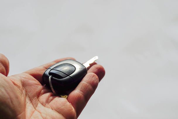 Car key in man hand close to view elszigetelt háttér - Fotó, kép