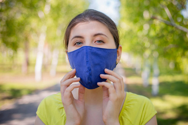 Portrait of a pensive woman in a blue mask on her face. - Foto, imagen