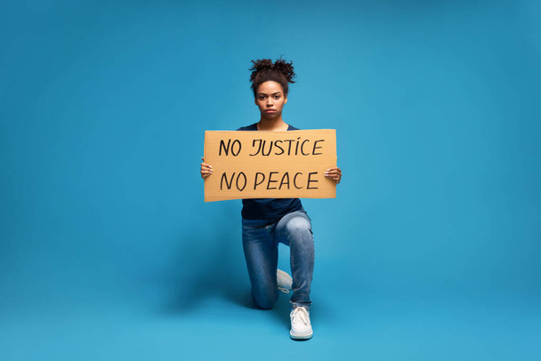 Чорна жінка стоїть з гаслом США про акцію протесту - Фото, зображення