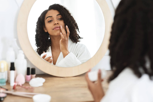 Lips Care. Piękny czarny kobieta stosując balsam nawilżający, refleksji w lustrze - Zdjęcie, obraz