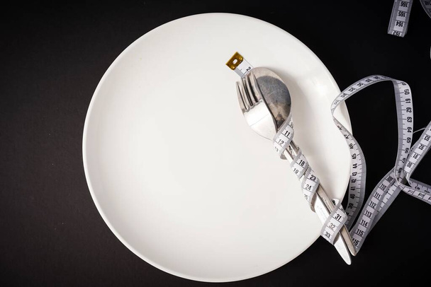 Conceito de alimentação saudável: prato branco com garfo e colher
 - Foto, Imagem