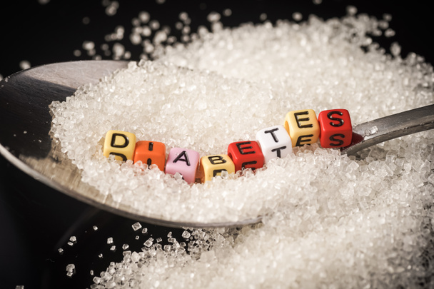Diabetes Concept: Diabetes wordings on top of sugar heaps. November is World Diabetes Month - Photo, Image