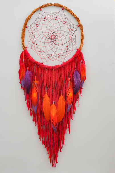Closeup details modern dreamcatcher with painted colorful feathers on gray background - Photo, Image