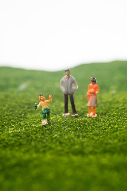 Glückliches Familienkonzept: Miniatur-Familienfiguren im Park. Selektive Fokussierung - Foto, Bild