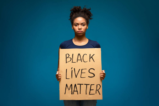 Африканская американка с плакатом с текстом BLM
 - Фото, изображение