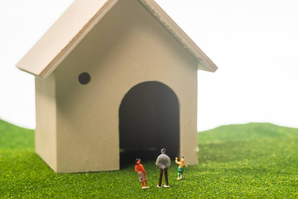 Personas en miniatura de de la casa de juguete. Concepto de familia feliz: una familia frente a una casa
 - Foto, Imagen