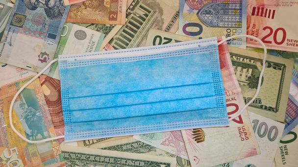 medyczna maska ochronna na papierowych banknotach pieniężnych różnych krajów - Zdjęcie, obraz