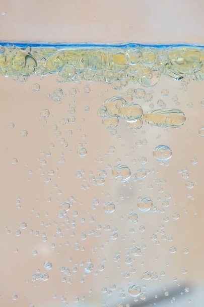 Bolhas de óleo na água com fundo bege
. - Foto, Imagem