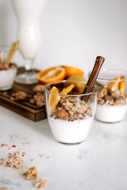 Natural yogurt and granola with slices of fruits and nuts in a glass cup, healthy breakfast.. High quality photo - Valokuva, kuva