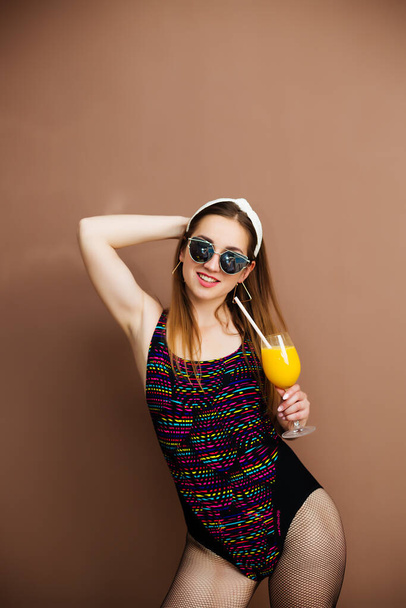 Portrait of smiling brunette girl in swimsuit in summer swimwear and sunglasses - Photo, image