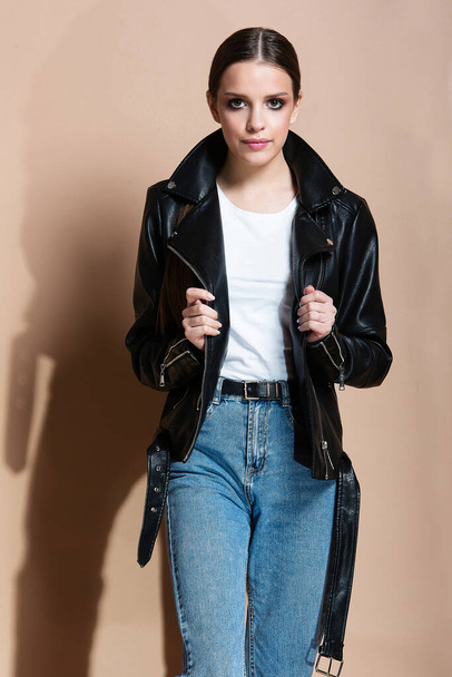 girls with big eyes in  leather jacket and jeans on  beige background - Photo, image