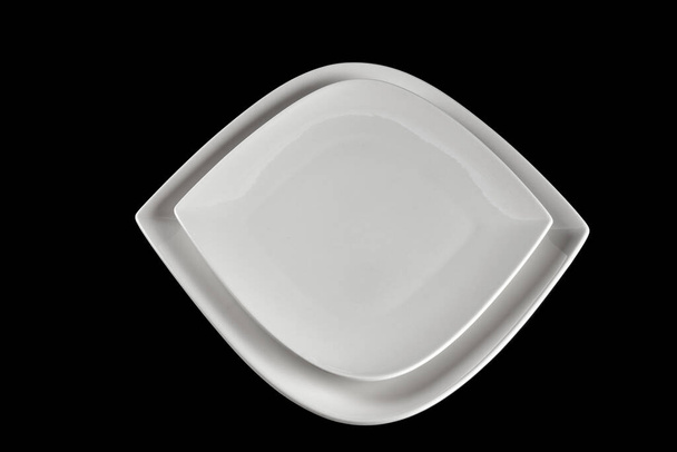 Bílý talíř shora pro potraviny izolované na černém. Kulaté prázdné jídlo na večeři na tmavém pozadí. Restaurace kuchyně minimalistický koncept. - Fotografie, Obrázek
