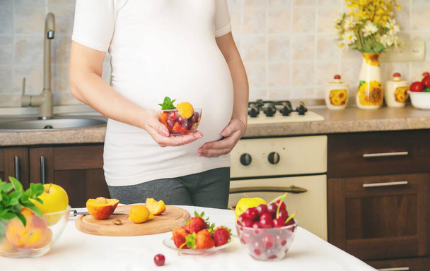 Une femme enceinte mange des fruits. Concentration sélective. produits alimentaires. - Photo, image