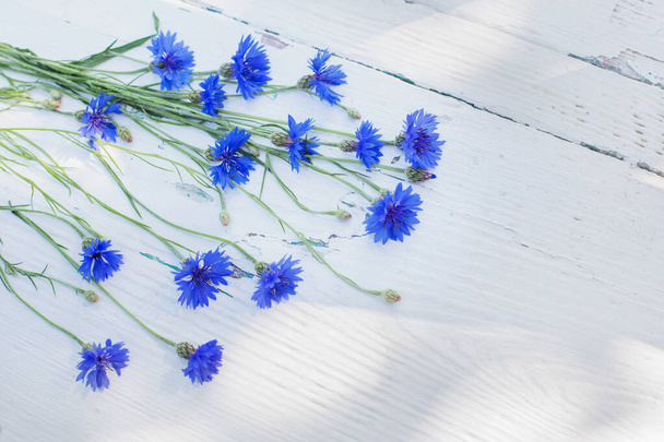 blue cornflowers on white old wooden background - Fotografie, Obrázek