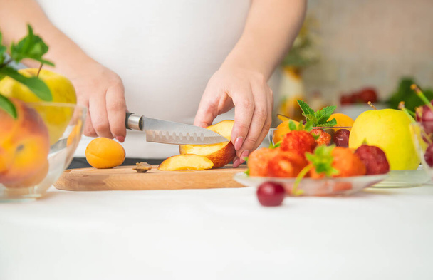 Une femme enceinte mange des fruits. Concentration sélective. produits alimentaires. - Photo, image