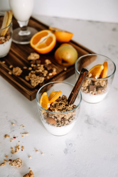 Natural yogurt and granola with slices of fruits and nuts in a glass cup, healthy breakfast.. High quality photo - Foto, imagen