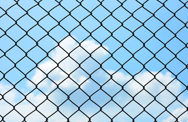 κλουβί μεταλλικό σύρμα τοίχο σε μπλε ουρανό - Φωτογραφία, εικόνα