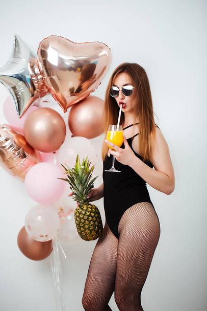 Summer bliss. Cheerful girl in a bathing suit enjoying a fruit cocktail - 写真・画像
