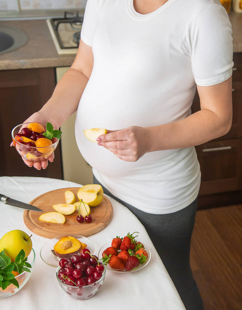 A pregnant woman eats fruit. Selective focus. food. - Fotoğraf, Görsel