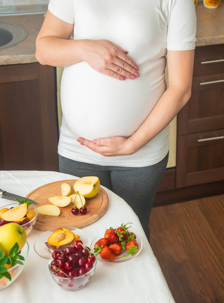 A pregnant woman eats fruit. Selective focus. food. - Zdjęcie, obraz