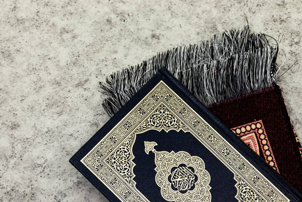 Ιερό Κοράνι με αραβική καλλιγραφία έννοια του Al Quran και χαλάκι προσευχής - Φωτογραφία, εικόνα