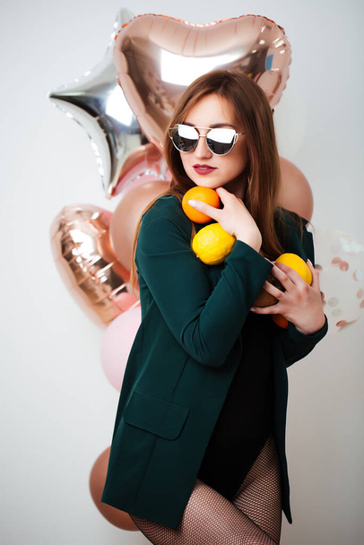 Smiling happy brunette fashionable woman holding balloons posing. Studio shot. - Fotó, kép
