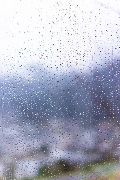 Arka planda bulanık pencere camına yağmur damlaları - Fotoğraf, Görsel