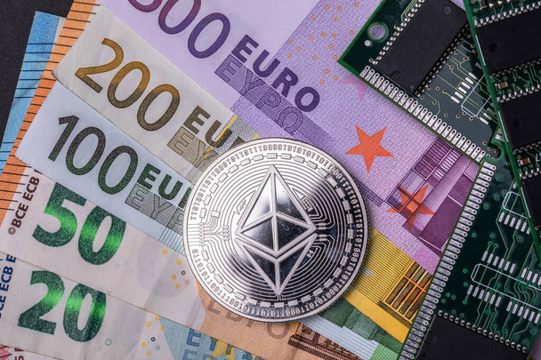Une monnaie Ethereum proche des micro-schémas, le tout placé par plusieurs billets en euros. Vue du dessus. - Photo, image