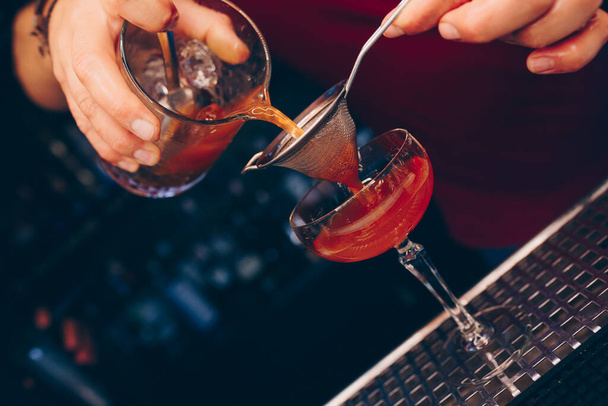 Baarimikko kaatamalla käyttäen siivilä Valkoinen terve Cocktail juoda baaritiskillä. Ammattimaista. Trendikäs tyylikäs alkoholijuoma. Suunnittelu ihmiset ja ylellisyyttä konsepti palvelun baarimikko yökerhossa
 - Valokuva, kuva