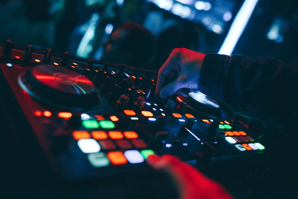 Parlayan müzik eşliğinde bir gece kulübünde DJ mikseri gece kulübü Live.de modern midi kontrol cihazıyla Dubstep Electronic Trance müzik çalar. Sanatçılar için müzik prodüksiyonu süreci. - Fotoğraf, Görsel