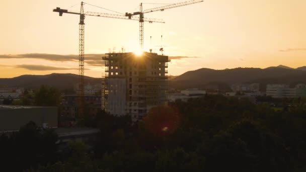 AERIAL: Volando hacia el edificio de apartamentos en construcción rodeado de grúas - Metraje, vídeo