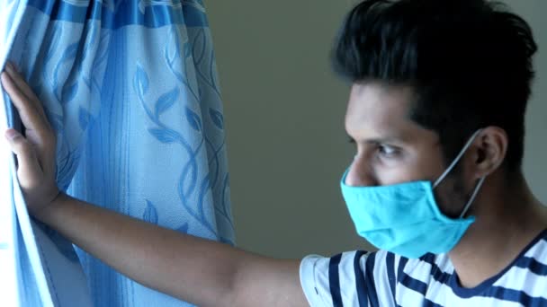A sad young asian man in protective mask looking through window  - Filmagem, Vídeo