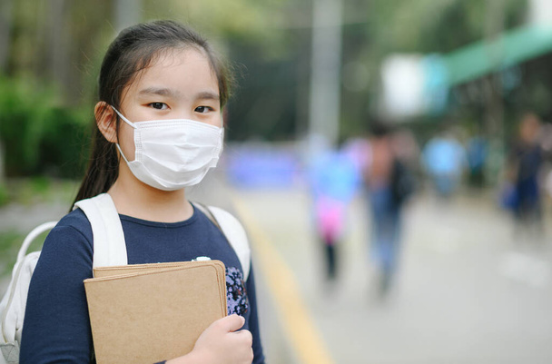 Vissza a suliba. ázsiai gyermek lány visel arc maszk hátizsák megy az iskolába .Covid-19 coronavirus pandemic.Új normális életmód.Oktatás koncepció. - Fotó, kép