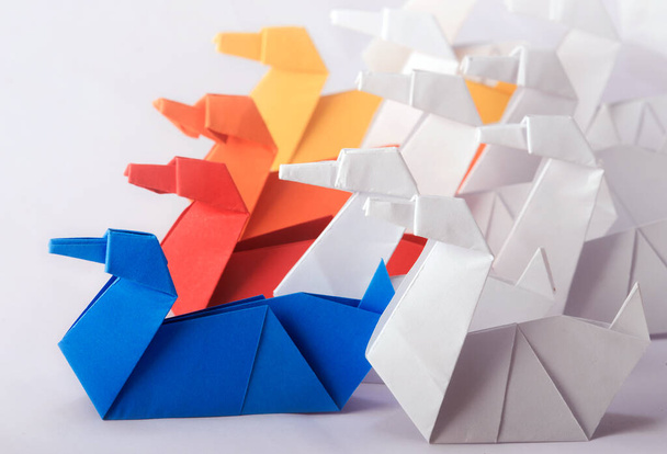 Tiimityöskentely / johtajuuskonsepti käyttäen eri väriä Origami Paper Swans. Tavoitteiden saavuttaminen tiimin yhteisten ponnistelujen avulla    - Valokuva, kuva