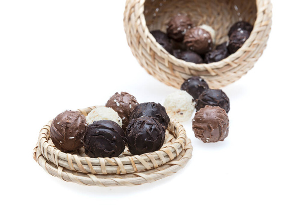 a closeup shot of a pile of black and white chocolate bonbons on a white background - Foto, imagen